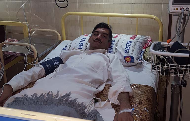 Abdul Salam laying on hospital bed